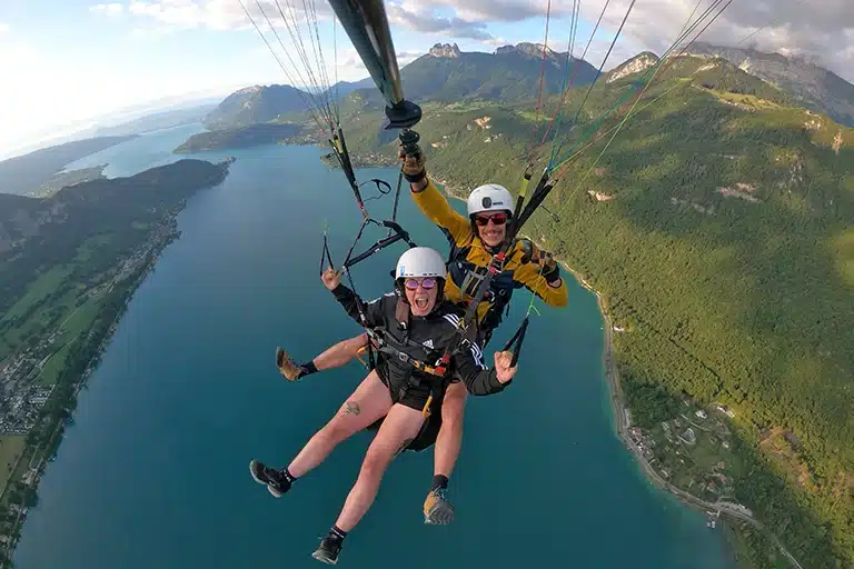 Photo d'un groupe d'amies célébrant un EVJF à Annecy, entourées du magnifique paysage alpin avec le lac en arrière-plan. Elles sourient et partagent des moments inoubliables lors d'une journée riche en activités et en émotions.