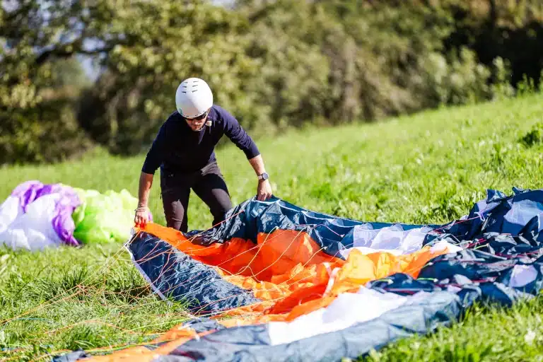 Élèves de parapente s'entraînant sur une pente école avec un moniteur.