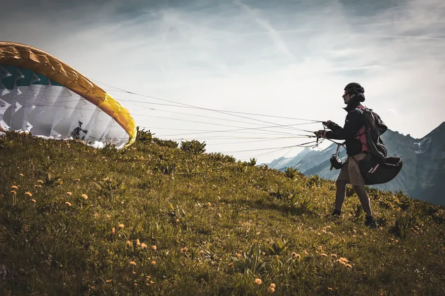 Pilote décollant depuis un sommet isolé lors d’un stage marche et vol dans les Alpes.