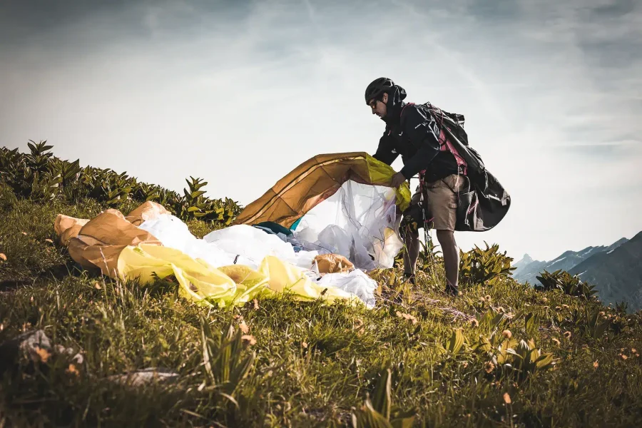 Préparation d’une voile avant un décollage sauvage en montagne lors d’un stage hike and fly.